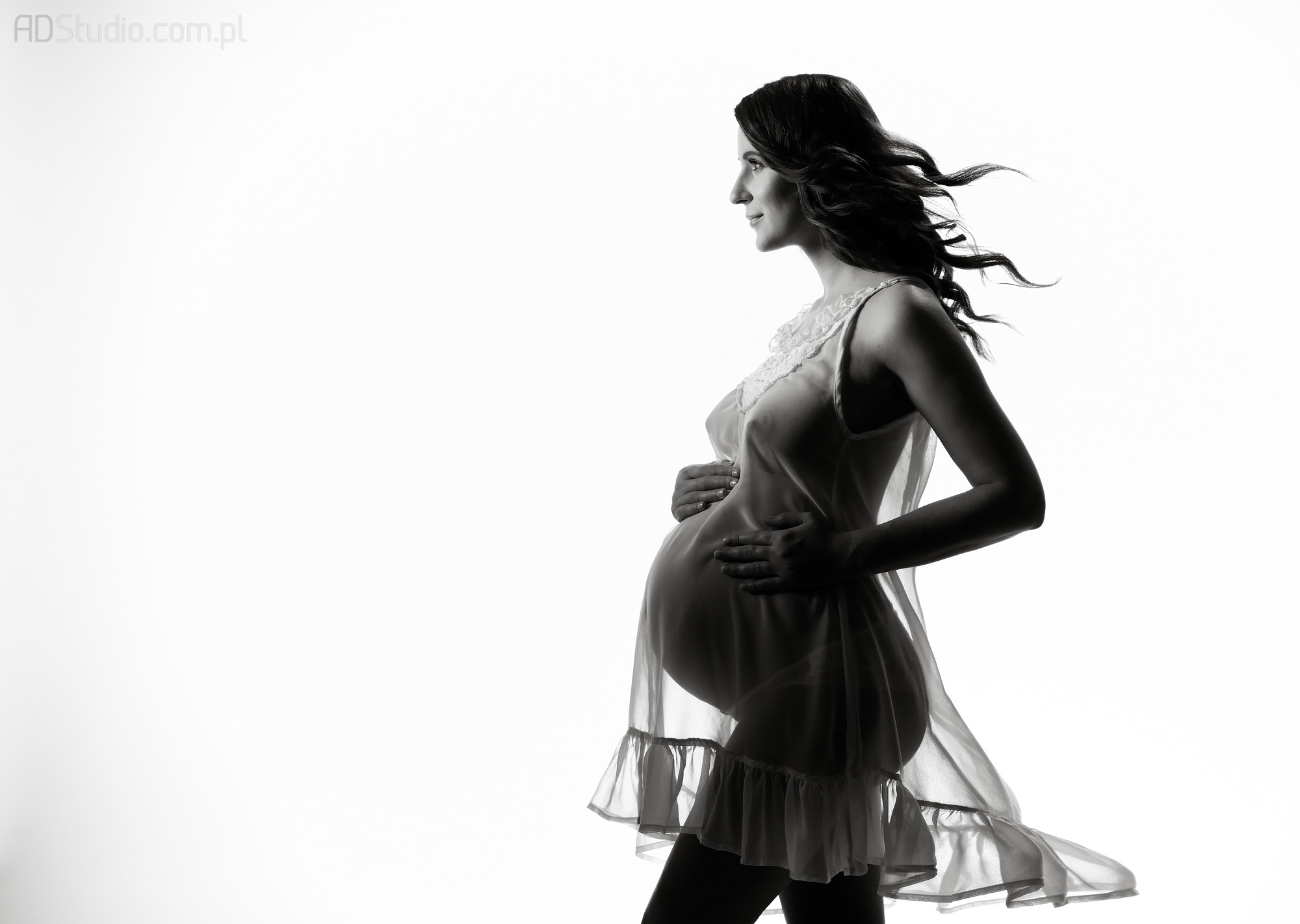 studyjna fotografia dziewczyny w zaawansowanej ciąży z rozwianymi włosami