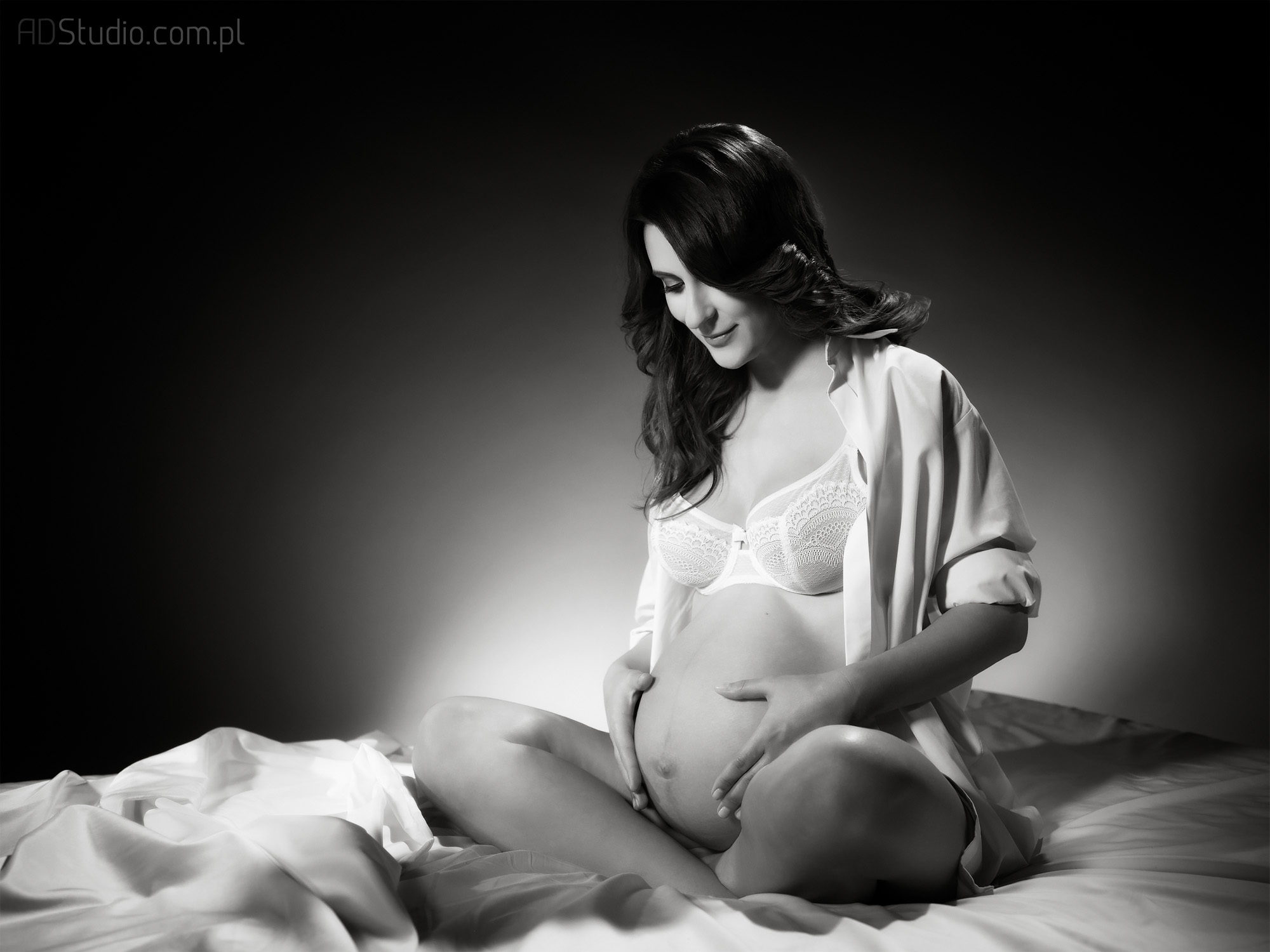 kobieta w ciąży siedząca na łóżku